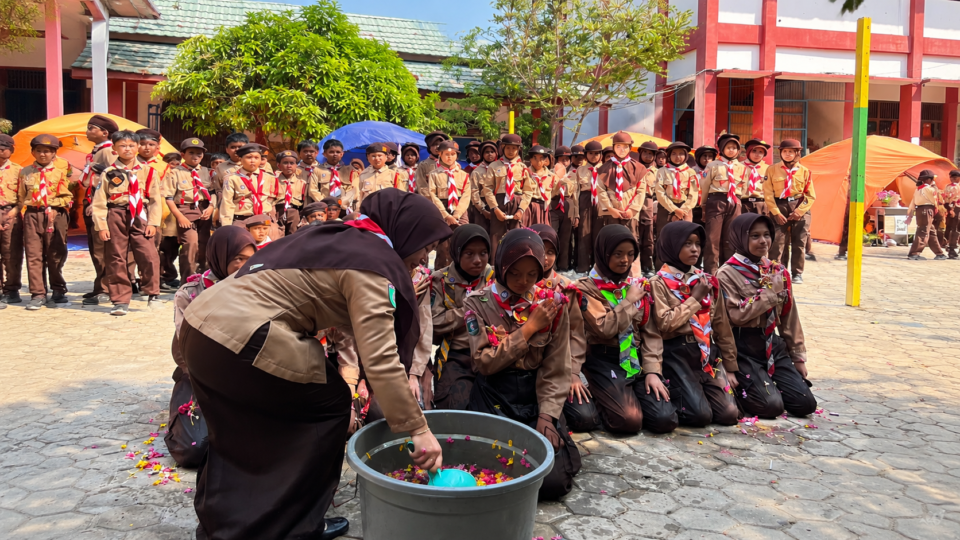 rosesi penyiraman air kembang dalam pelantikan Penggalang Ramu menjadi simbol penyucian diri dan kesiapan anggota Pramuka SDN 001 Sangatta Selatan untuk mengemban tanggung jawab baru dalam Gerakan Pramuka